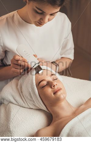 Cosmetologist With Ultrasonic Scrubber Working With Womans Face Skin. Ultrasound Cosmetology Scrubbe