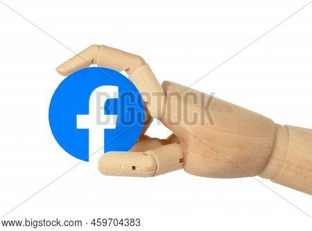 Kiev, Ukraine - May 03, 2022: Wooden Hand Holds Round Facebook Paper Icon, On White Background. Face