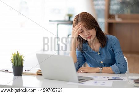 Smiling Pretty Girl Working On Laptop Computer While Sitting At Office Table, Taking Notes In A Diar