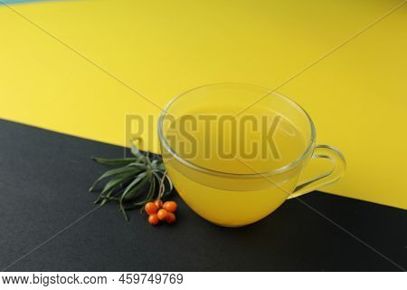 Sea Buckthorn Tea Drink On A Black Yellow Bright Background. Sea Buckthorn Drink Tea Juice In A Glas