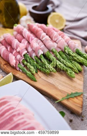 Cooking Green Aspargus Covered With Bacon At Domestic Kitchen