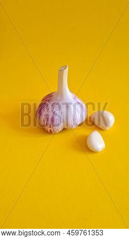 Fresh Garlic And A Few Cloves Of Garlic On A Yellow Background.