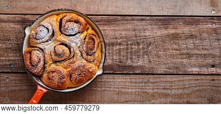 Cinnabon Cinnamon Rolls Buns With Pumpkin, Nut, Caramel And Sugar Cream Iced On Rustic Wooden Backgr