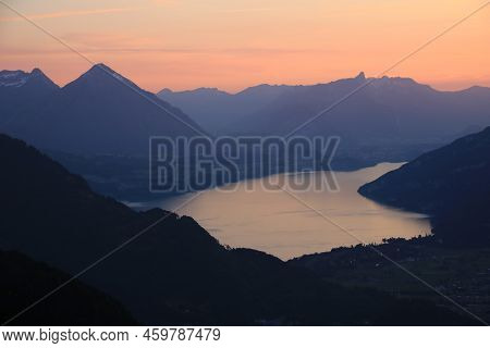 Red Evening Sky Over Lake Thun And Mountain Ranges In Switzerland.