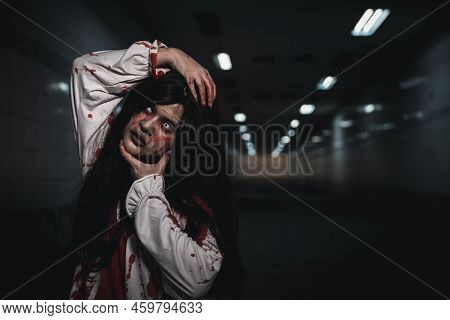 Happy Halloween Day Concept. Screaming Zombie Female Face With Blood Grabs Her Head To Twist It Off,