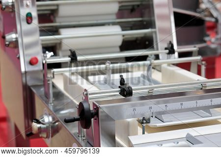 Automatic Cellophane Wrapping Machine In Food Production Factory. Selective Focus.