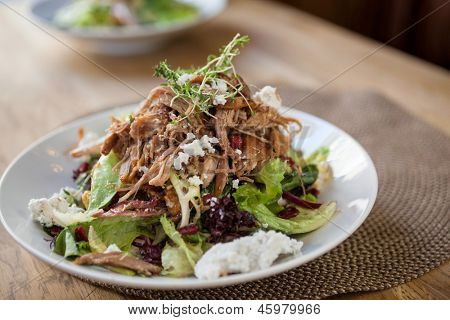 Closeup di insalata di pollo guarniti al tavolo nel ristorante