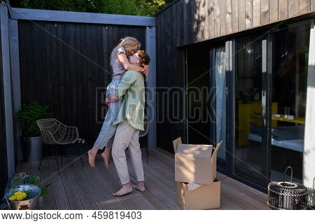 Cheerful Young Couple Moving In Their New Tiny House In Woods. Conception Of Moving And Sustainable 