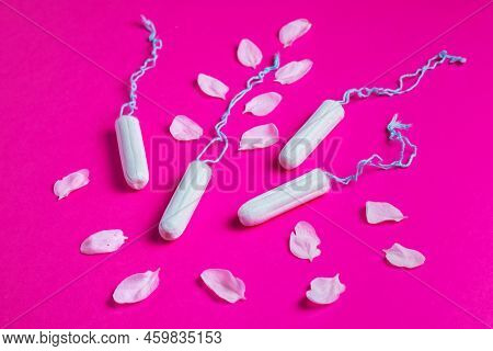 Female Tampons With With Cherry Petals On A Pink Background. Hygienic White Tampon For Women. Cotton