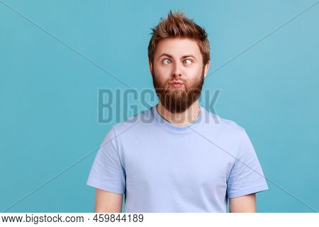 Portrait Of Man Making Silly Humorous Face With Eyes Crossed, Showing Comical Silly Brainless Facial