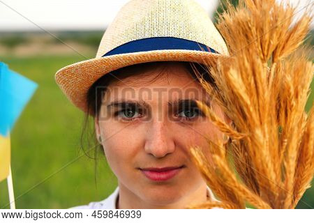Defocus Young Ukrainian Woman Portrait. Bouquet Of Ripe Golden Spikelets Of Wheat Tied On The Meadow