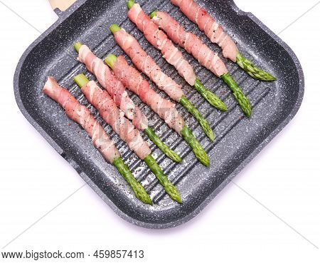 Aspargus Covered With Bacon In A Grill Frying Pan Isolated On White Background