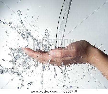 mani umane con acqua schizzi su di loro