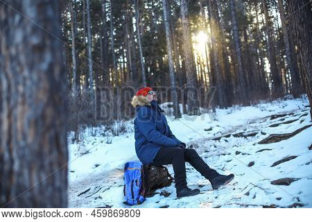 Traveller Man In A Blue Winter Jacket Ad Red Cap In The Woods. Sandy Bay, Baikal Lake, Winter Time. 