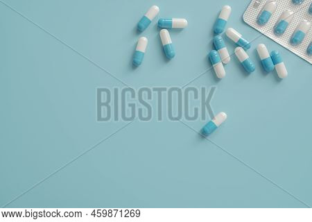 Antibiotic Capsule Pills On Blue Background. Prescription Drugs. Blue-white Capsule Pills. Antibioti