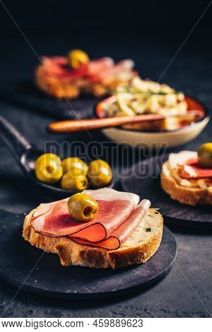 Roasted Bread Or Open Sandwich With Garlic Butter Spread And Serano Ham And Olive On Dark Background