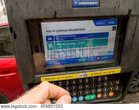 Strasbourg, France - Mar 31, 2022: Pov Male Hand Looking At Parkeon Parking Meters With Digital Disp