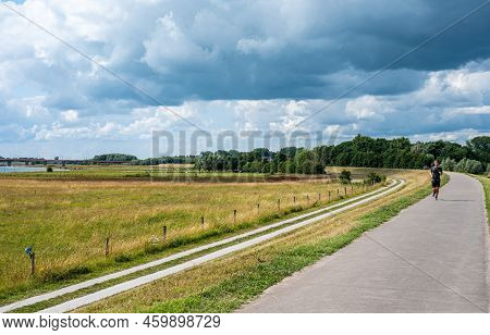 Zwolle, Overijssel, The Netherlands, 07 15 2022 - Bicycle Path At The Dike Of The River Ijssel Flood
