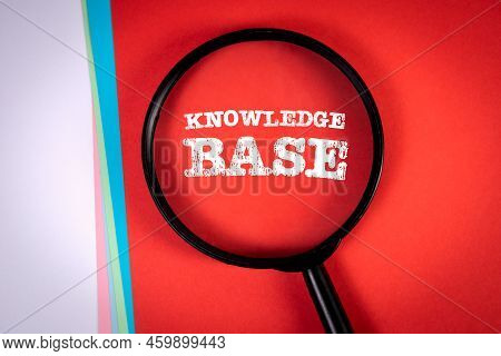 Knowledge Base. Search And Research Concept. Magnifying Glass On A Red Background