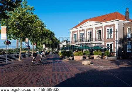 Zaltbommel, Gelderland, The Netherlands - 07 12 2022 - Cyclists Passing A Restaurant And Terrace Wit