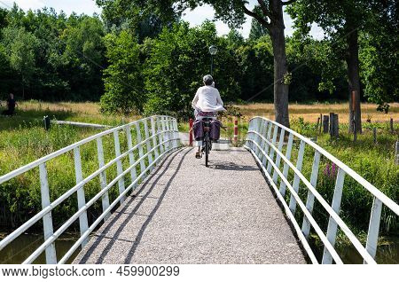 Ulvenhout, North Brabant, The Netherlands, 08 09 2022 - Cyclist Driving A Bridge Over The River Mark