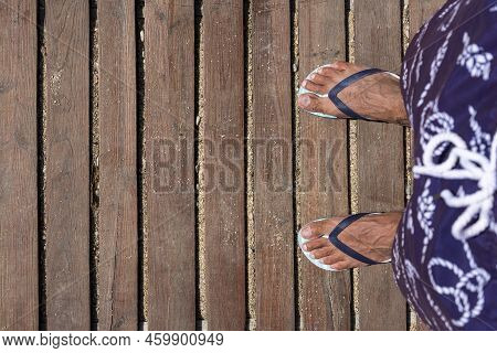 Mans Feet In Flip Flops On Wooden Boardwalk. Top View. Flat Lay. Empty Space, For Text