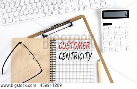 Notebook With The Word Customer Centricity With Keyboard And Calculator On White Background