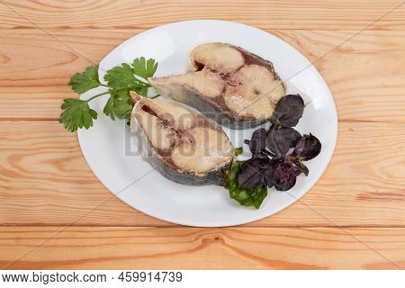 Baked Pieces Of The Japanese Amberjack Or Yellowtail And Twigs Of The Fresh Greens On A White Dish O