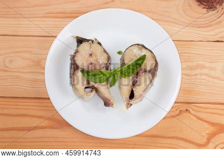 Baked Pieces Of The Japanese Amberjack Or Yellowtail With Leaves Of The Fresh Basil On A White Dish 