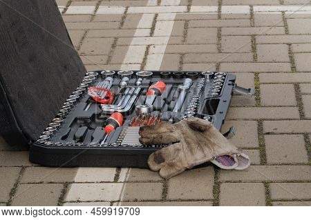 Mechanical Workshop Tools. Car Mechanic Using Different Repair Tools For Repairing An Orange Car. To