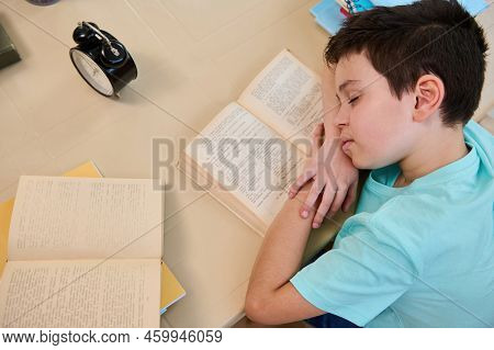 Overhead View Of A Primary School Student, Falling Asleep On A Textbook, Feeling Tired Doing Homewor