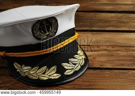 Peaked Cap With Accessories On Wooden Background, Closeup. Space For Text