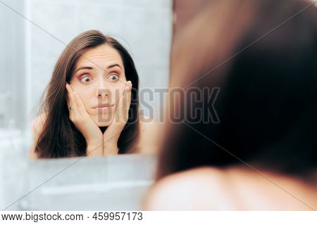 Worried Woman In Her 30s Checking Herself In The Mirror