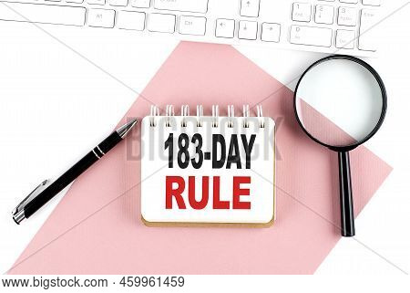 Business Concept. Notebook With Text 183-day Rule On Pink Paper With Magnifier, Keyboard And Pen In 