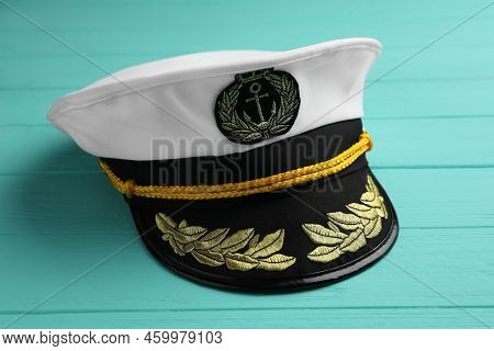 Peaked Cap With Accessories On Turquoise Wooden Background