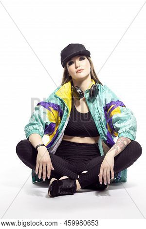 Portrait Of Young Caucasian Female  Sportwoman In Fitness Outfit And Baseball Cap With Wireless Head