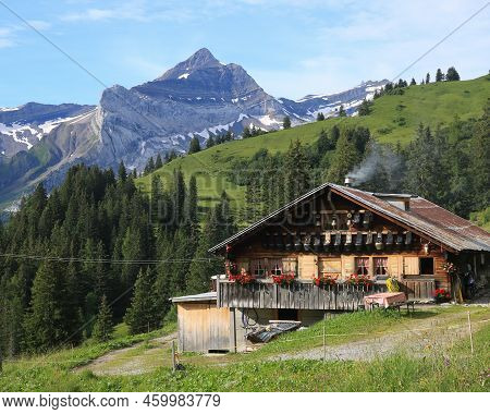 Old Farm House With Cow Bells On The Facade And Mount Oldehore.