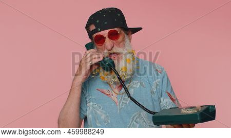 Crazy Stylish Senior Man With Flowers In Gray-haired Beard Talking On Wired Vintage Telephone Of 80s