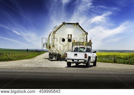 Rocky View County Alberta Canada, July 28 2022: An oversized load of grain silos carried on a semi t