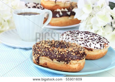 Sweet donuts with cup of tea on table close-up
