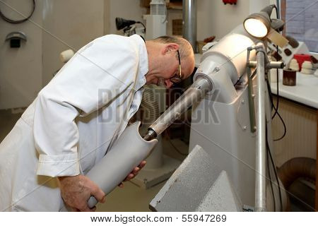 A Worker At A Tunnel Grinding Machine.