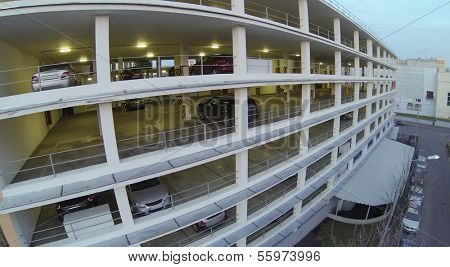 Cars parked in multistoried parking at evening. View from unmanned quadrocopter