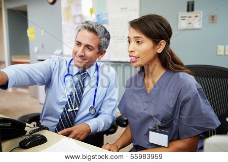 Doctor With Nurse Working At Nurses Station