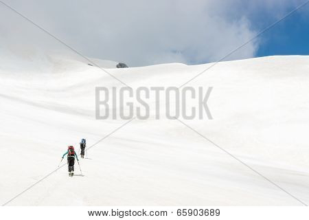 Skiiers Ascending Mountain Slope