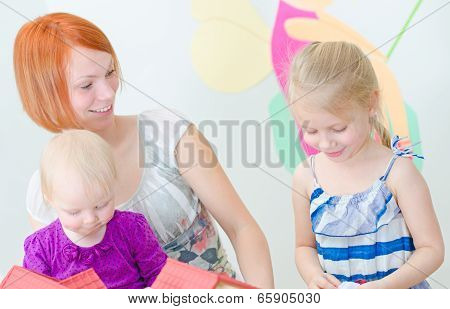 Children And Their Mother Playing With Dollhouse.