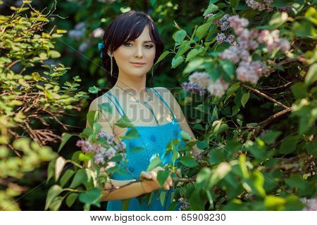 Portrait Of A Beautiful Brunette Girl In The Garden.