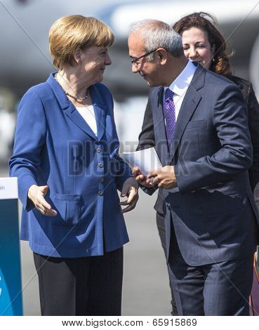 BERLIN, GERMANY - MAY 20, 2014: German Chancellor Angela Merkel (L), Turkish Minister of transport Lutfi Elvan (R) open up the International aviation and space exhibition ILA.