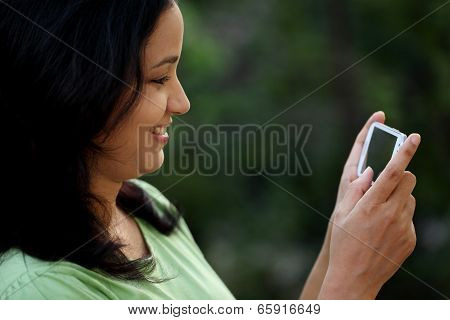 Happy Young Woman Text Messaging At Outdoors