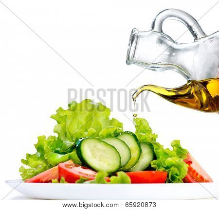 Healthy Vegetable Salad with Olive oil dressing isolated on white background. Pouring Olive oil. Healthy vegetarian food. Vegan. Diet, dieting concept. Lettuce, tomatoes, cucumbers. Organic bio food