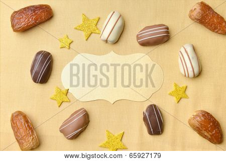 Empty golden seal surrounded by date chocolates and dates